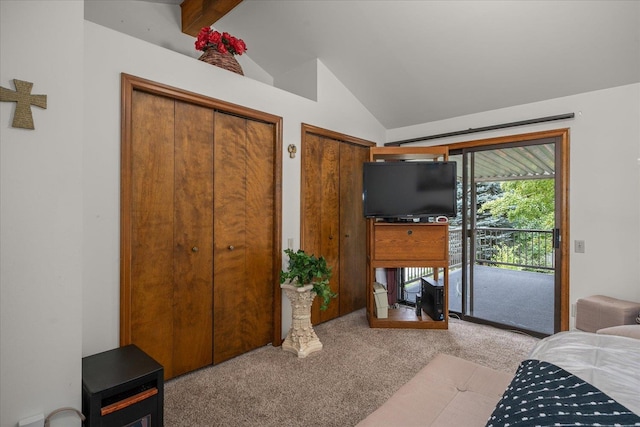 carpeted bedroom with vaulted ceiling with beams, two closets, and access to outside