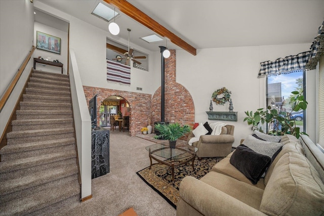 living room with beam ceiling, a wood stove, carpet floors, high vaulted ceiling, and ceiling fan