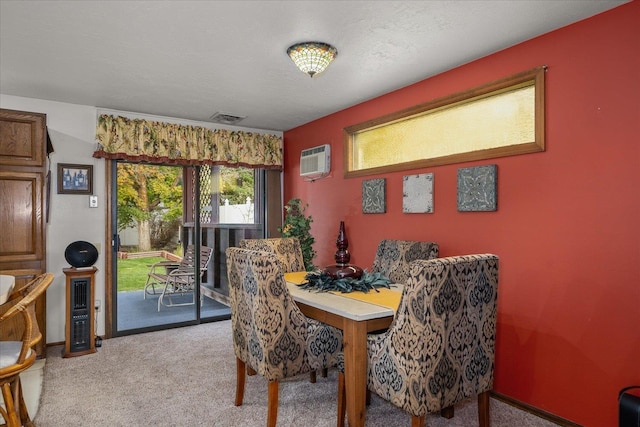 dining space with a textured ceiling, light colored carpet, and an AC wall unit