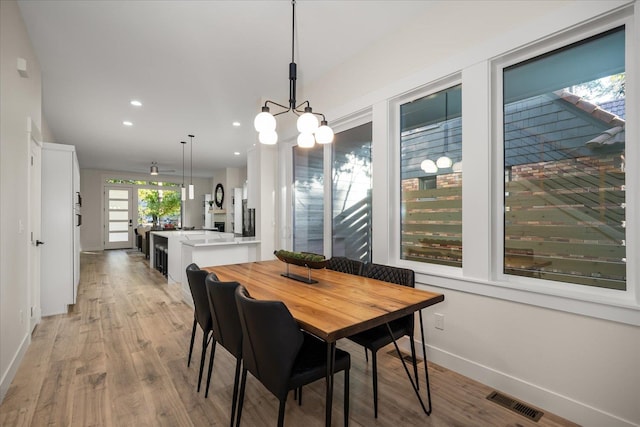 dining area with a notable chandelier and light hardwood / wood-style floors