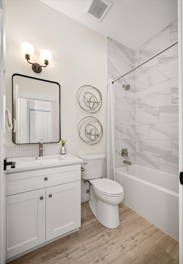 full bathroom with decorative backsplash, hardwood / wood-style flooring, toilet, vanity, and shower / tub combo with curtain