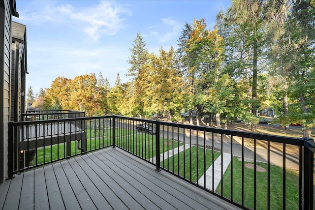 wooden terrace featuring a lawn