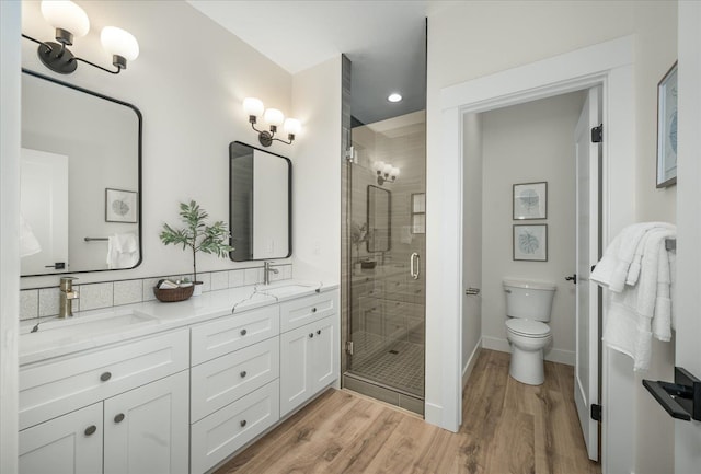 bathroom with vanity, an enclosed shower, toilet, and wood-type flooring