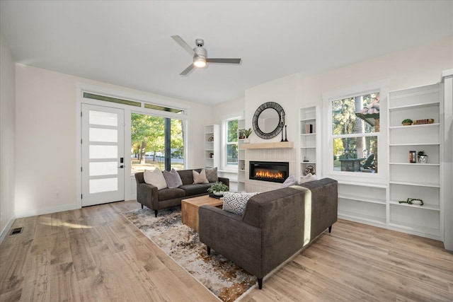 living room with light hardwood / wood-style flooring, plenty of natural light, and ceiling fan