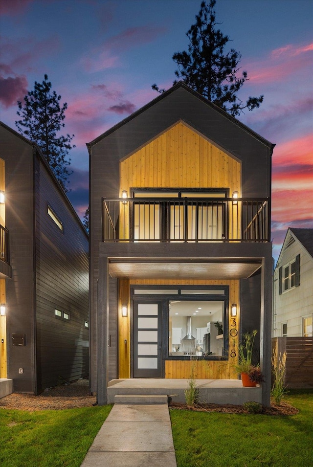 modern home with a lawn and a balcony