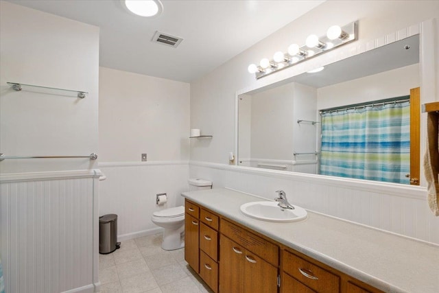 bathroom featuring vanity, toilet, and curtained shower