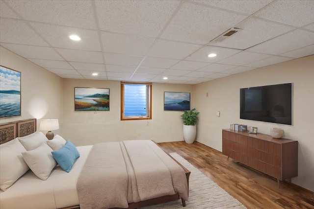 bedroom featuring light hardwood / wood-style floors and a paneled ceiling