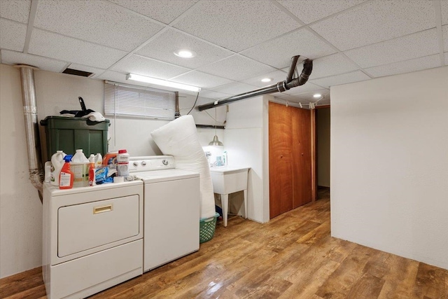 clothes washing area featuring light hardwood / wood-style flooring and washing machine and clothes dryer