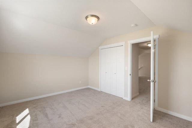 additional living space with lofted ceiling and light colored carpet