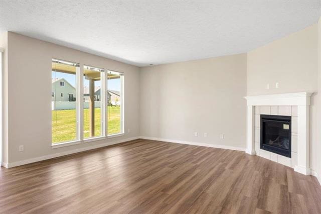 unfurnished living room with a textured ceiling, a fireplace, and wood-type flooring