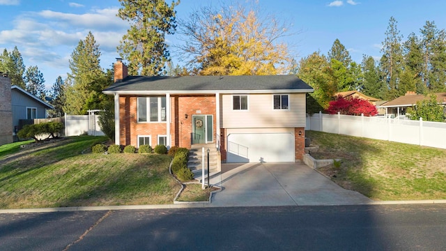 split foyer home featuring a garage and a front lawn