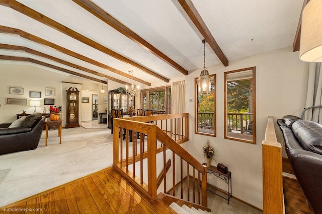 interior space with a notable chandelier, wood-type flooring, and vaulted ceiling with beams