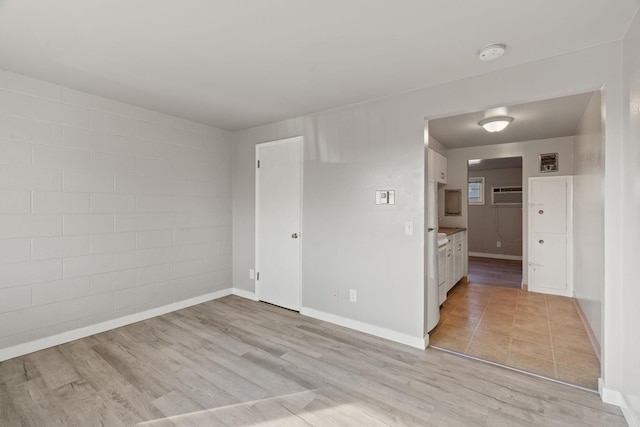 empty room featuring light hardwood / wood-style floors and a wall mounted AC