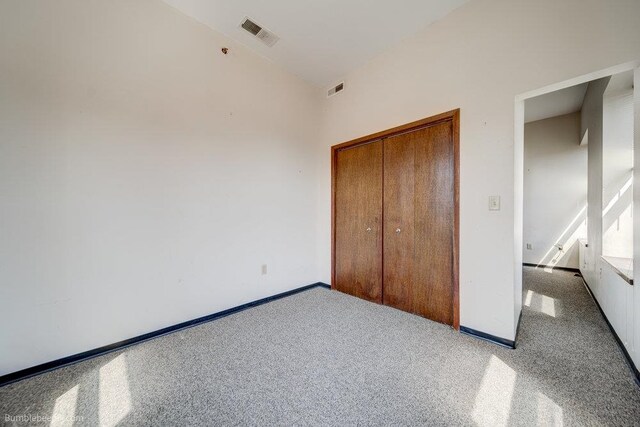 unfurnished bedroom featuring a closet and light colored carpet