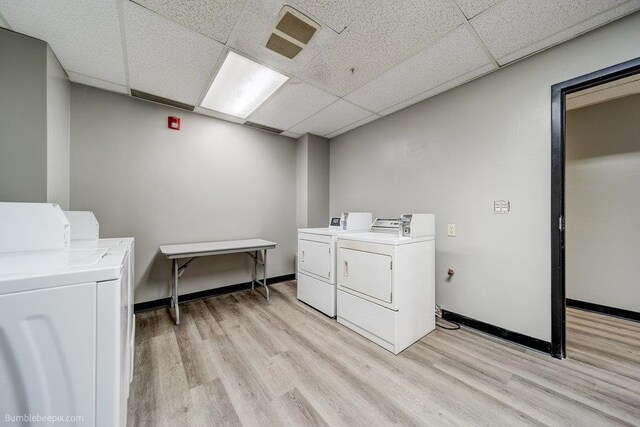 laundry area with light hardwood / wood-style floors and separate washer and dryer