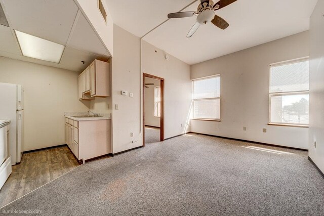 kitchen featuring sink, light hardwood / wood-style flooring, white fridge, and ceiling fan