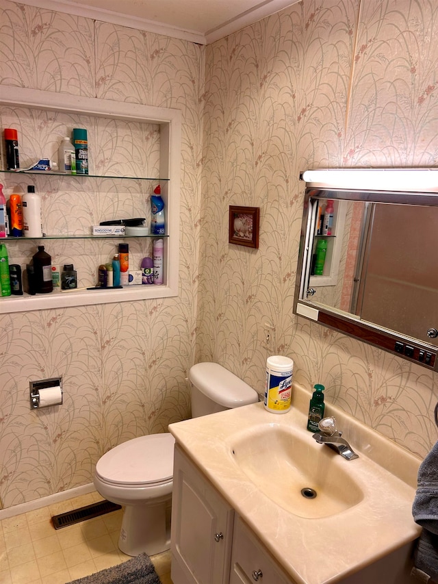 bathroom featuring vanity, toilet, ornamental molding, and tile patterned flooring