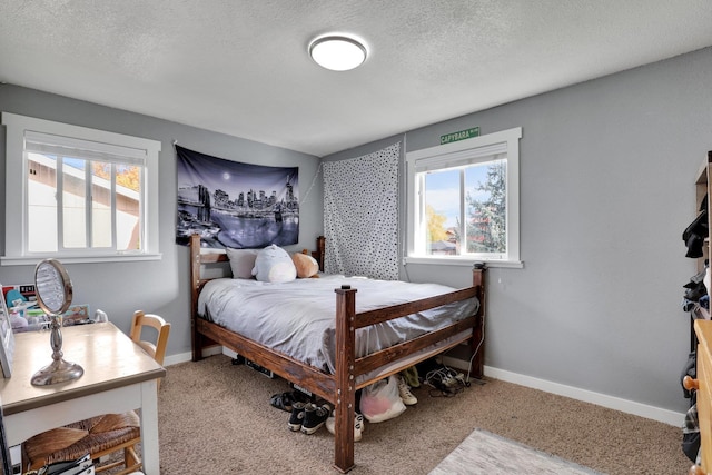 carpeted bedroom featuring a textured ceiling and multiple windows