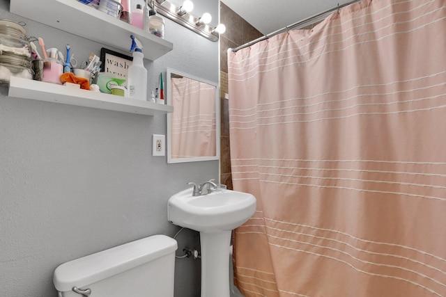 bathroom with a shower with shower curtain and toilet