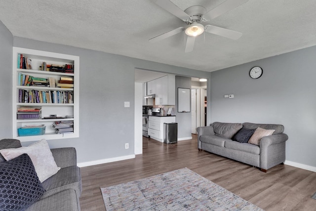 living room with dark hardwood / wood-style floors, a textured ceiling, and ceiling fan