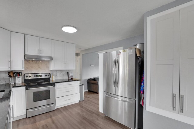 kitchen featuring stainless steel appliances, wood-type flooring, tasteful backsplash, and white cabinets