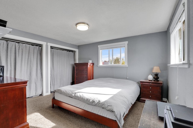 bedroom with dark carpet and a textured ceiling