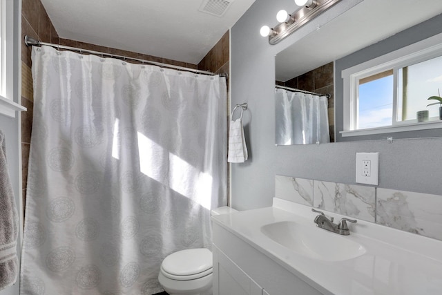 bathroom featuring vanity, toilet, and walk in shower