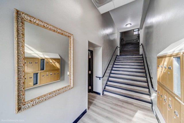 staircase featuring mail boxes and hardwood / wood-style flooring