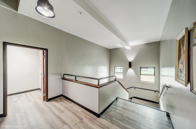 staircase with hardwood / wood-style flooring and beamed ceiling