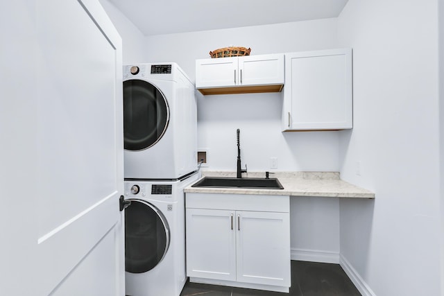 washroom featuring sink, stacked washer and clothes dryer, dark tile patterned flooring, and cabinets