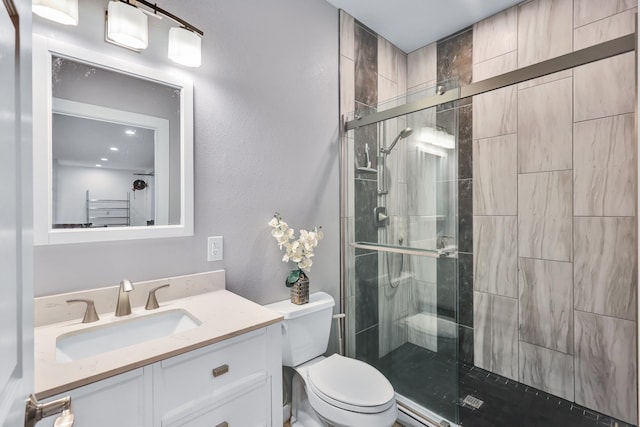 bathroom featuring toilet, vanity, and a shower with door