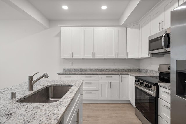 kitchen with white cabinets, recessed lighting, appliances with stainless steel finishes, and a sink