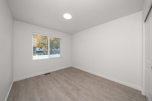 unfurnished room with baseboards, visible vents, and light wood-style floors