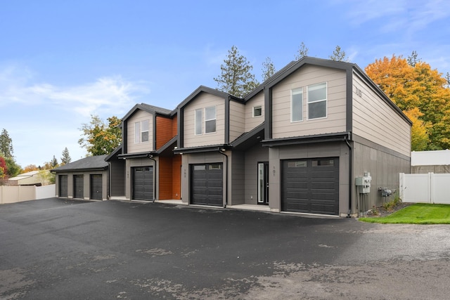 view of front of house with an attached garage and fence