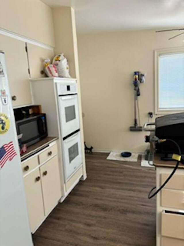 kitchen featuring dark wood-type flooring, white appliances, and white cabinetry