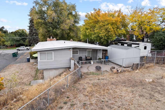 back of house featuring a storage unit