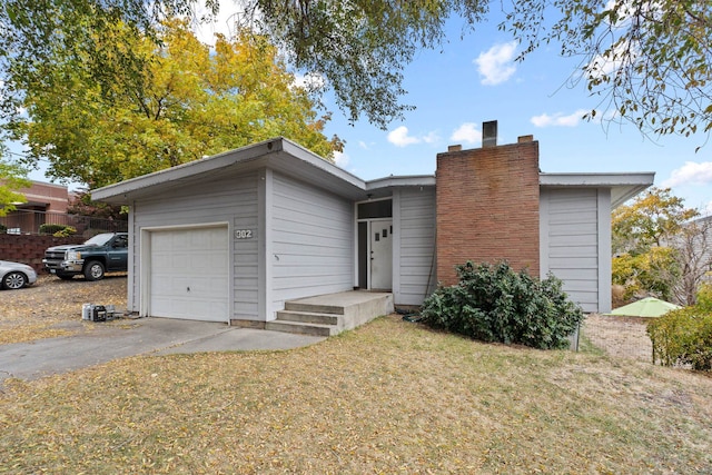 302 N Argonne Rd, Spokane Valley, WA 99212 - view of front facade with driveway, a front yard, a chimney, and an attached garage