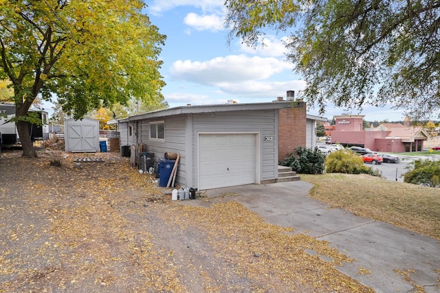 302 N Argonne Rd, Spokane Valley, WA 99212 - view of side of home with driveway, a storage unit, an outbuilding, and a detached garage