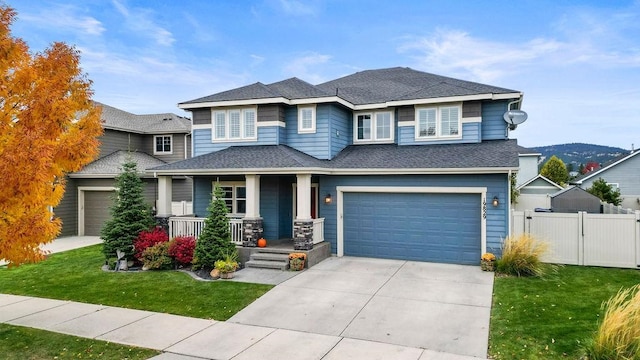 view of front of home featuring a front yard, a porch, and a garage