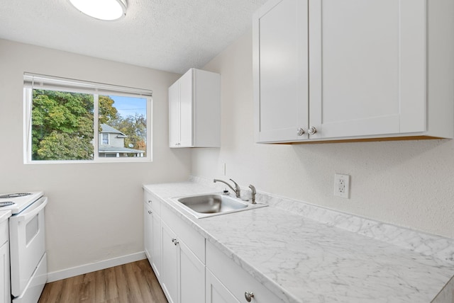 kitchen featuring light hardwood / wood-style flooring, white electric range, sink, and white cabinets