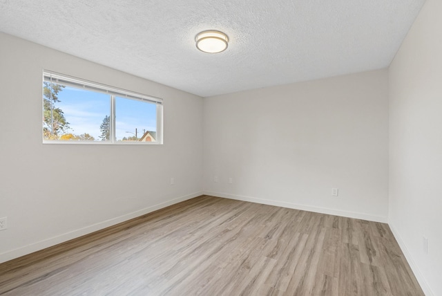 unfurnished room featuring light hardwood / wood-style flooring and a textured ceiling