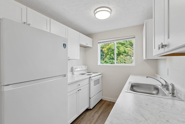 kitchen with white appliances, light hardwood / wood-style flooring, white cabinetry, and sink