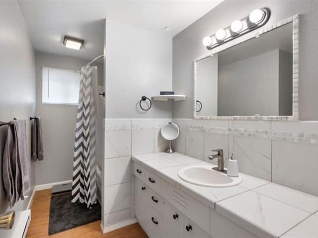 bathroom with vanity, hardwood / wood-style floors, curtained shower, and tile walls