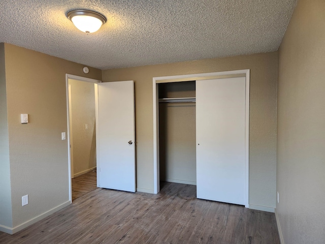 unfurnished bedroom featuring a closet, a textured ceiling, and hardwood / wood-style floors