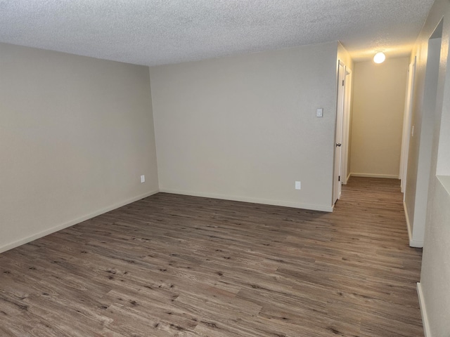 empty room with a textured ceiling and hardwood / wood-style flooring