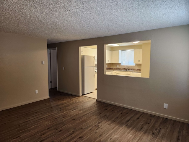 empty room featuring a textured ceiling, sink, and dark hardwood / wood-style floors