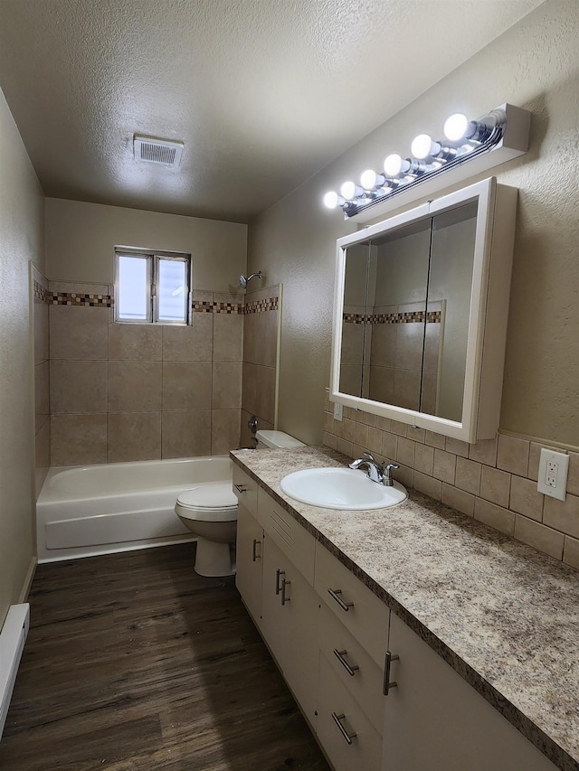 711 E Broad Avenue 715E Broad Ave, Spokane, WA 99207 - bathroom featuring wood finished floors, a textured ceiling, decorative backsplash, toilet, and visible vents