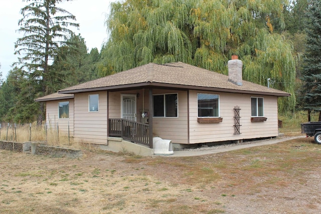 view of front of house featuring a chimney and a shingled roof