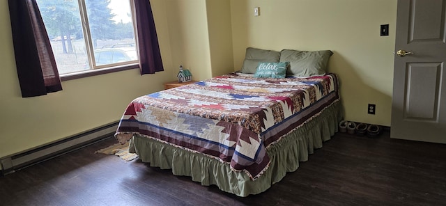 bedroom featuring a baseboard heating unit and wood finished floors