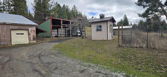 exterior space featuring aphalt driveway, a garage, and an outdoor structure